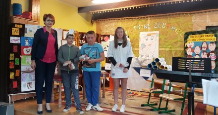 Dzieci z panią nauczyciel na tle prac plastycznych