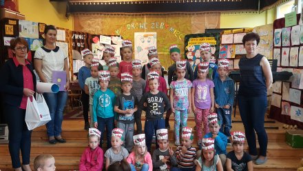 Dzieci z panią nauczyciel na tle prac plastycznych