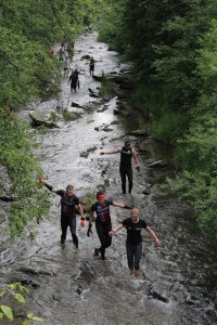Uczestnicy przeprawiają się przez rzekę