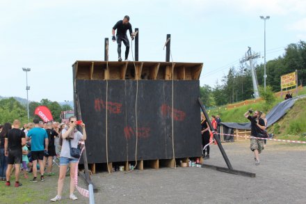 Uczestnicy pokonują ścianę - jedną z przeszkód