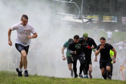 Przemoknięci zawodnicy biegną pod górę